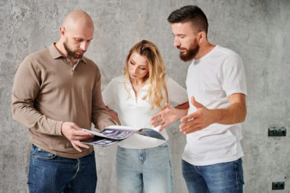Couple choosing interior design for apartment with specialist.