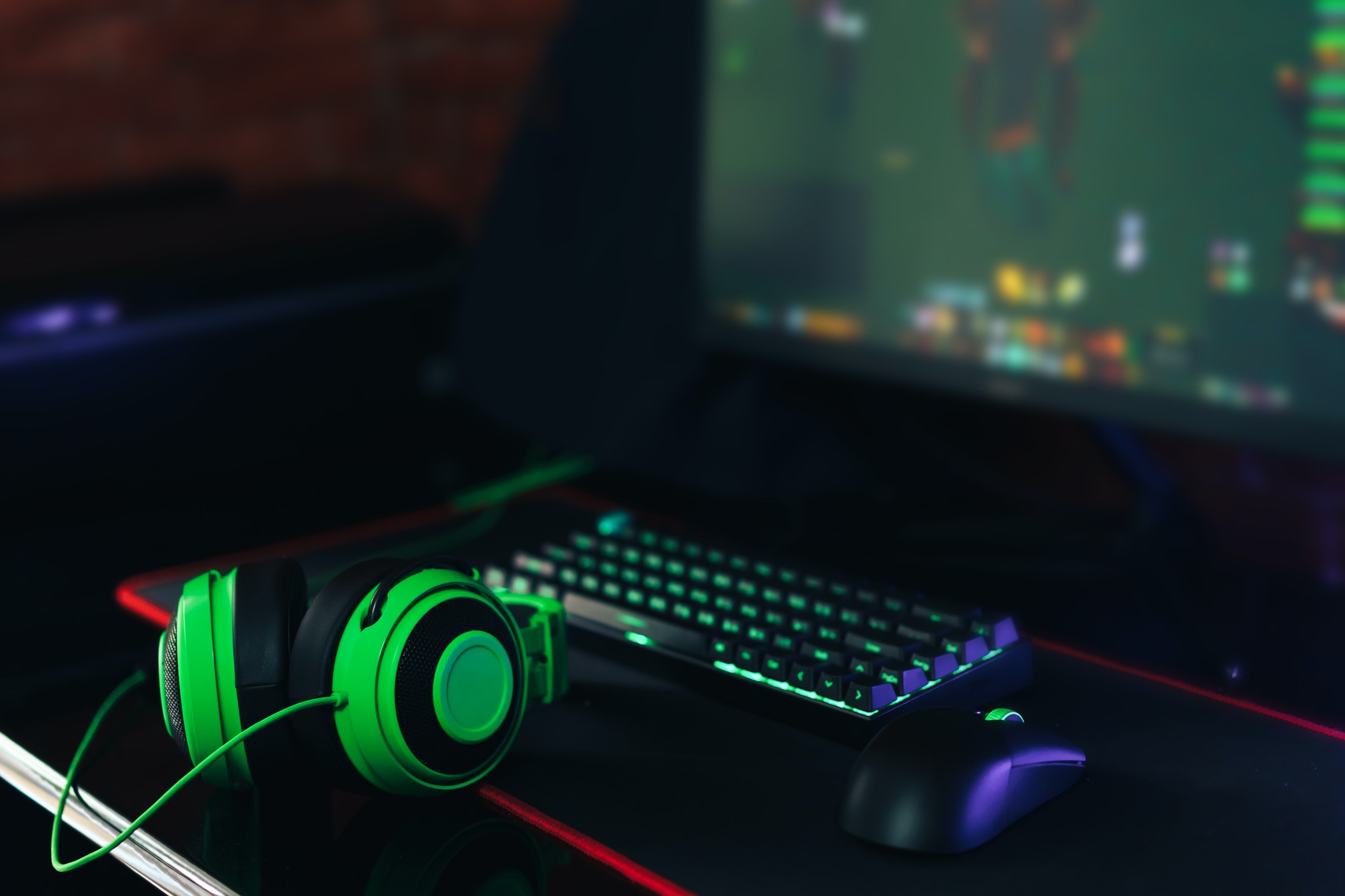 Gaming accessories with green backlight in front of the monitor