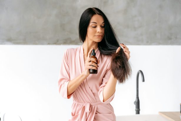 Hair spray. Female beauty routine. Hair care concept. Beautiful brunette caucasian woman applying