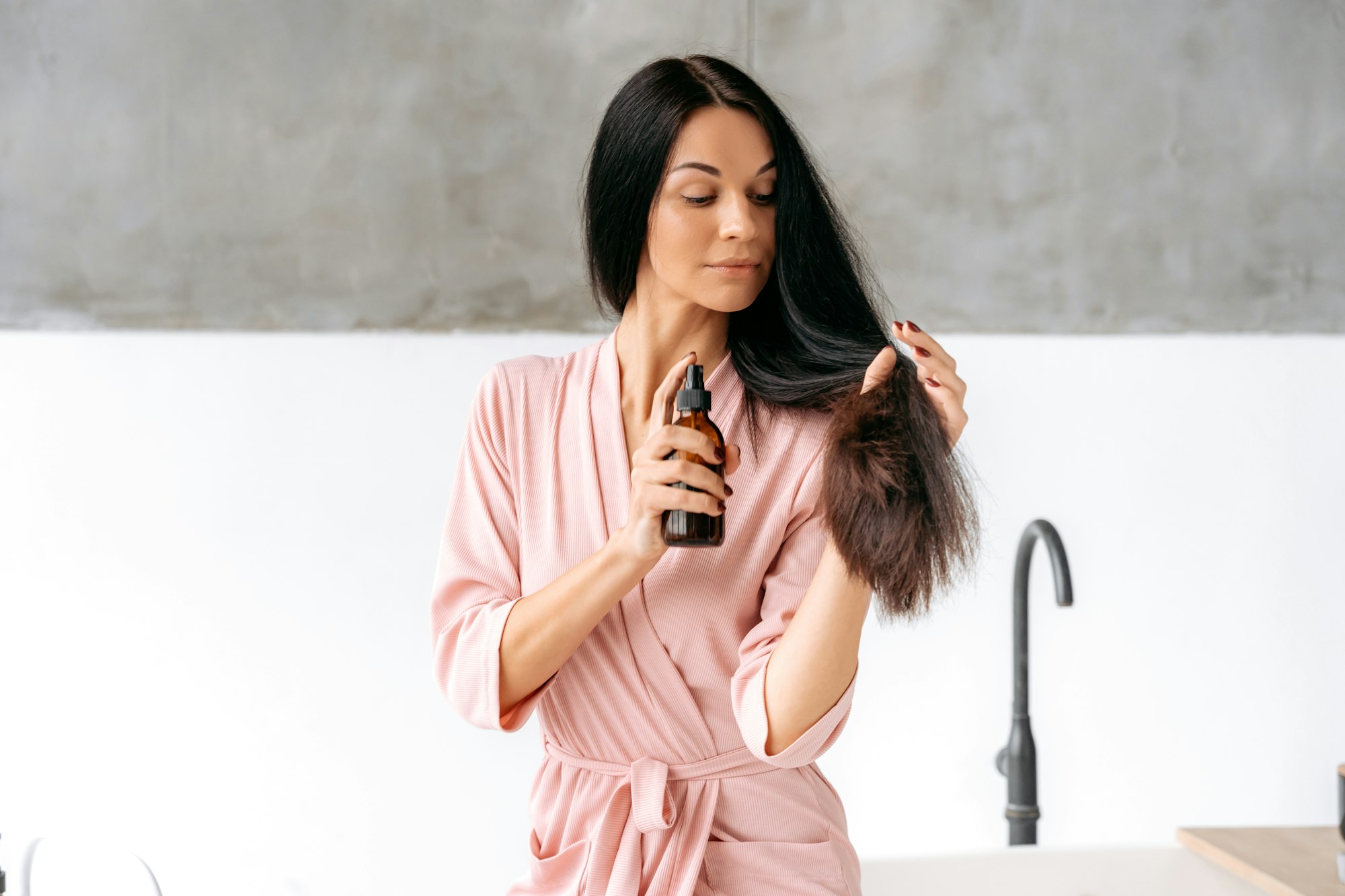 Hair spray. Female beauty routine. Hair care concept. Beautiful brunette caucasian woman applying