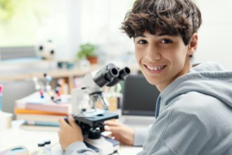 Happy student using a microscope