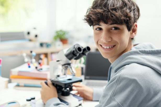 Happy student using a microscope