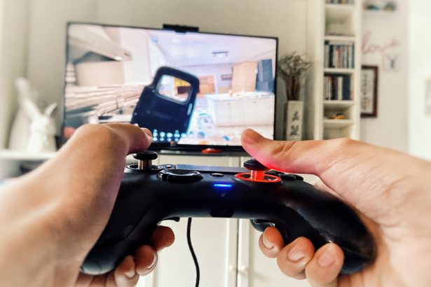 Playing videogame PlayStation holding teen hands on controller