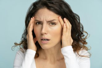 Worried woman has signs of aging skin, checking crows feet troubled with wrinkles on face, isolated