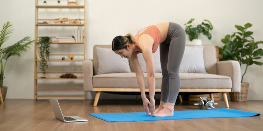 Young woman Exercising At Laptop Having Online Training At Home